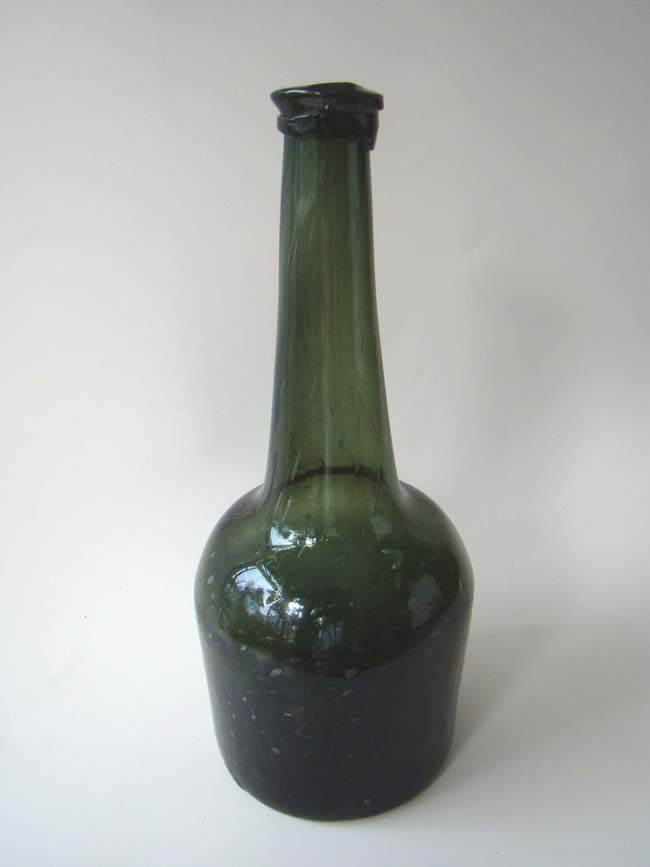 An unusually tall and rare 18th century English green glass wine bottle circa 1740